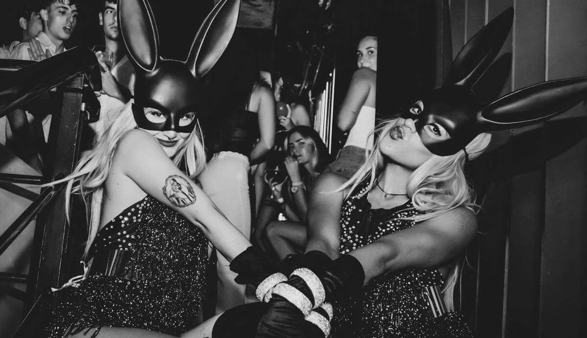 Black-and-white close-up of friends partying in a crowded nightclub.