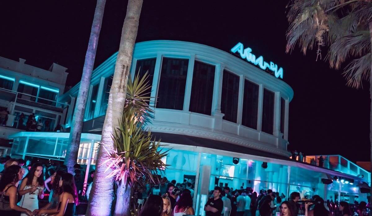 Entrance exterior of Akuarela Playa Valencia with people arriving at night.