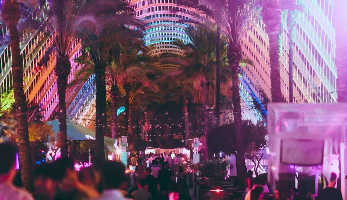 L’Umbracle terrace at night with colorful lighting and palm trees near the City of Arts and Sciences.