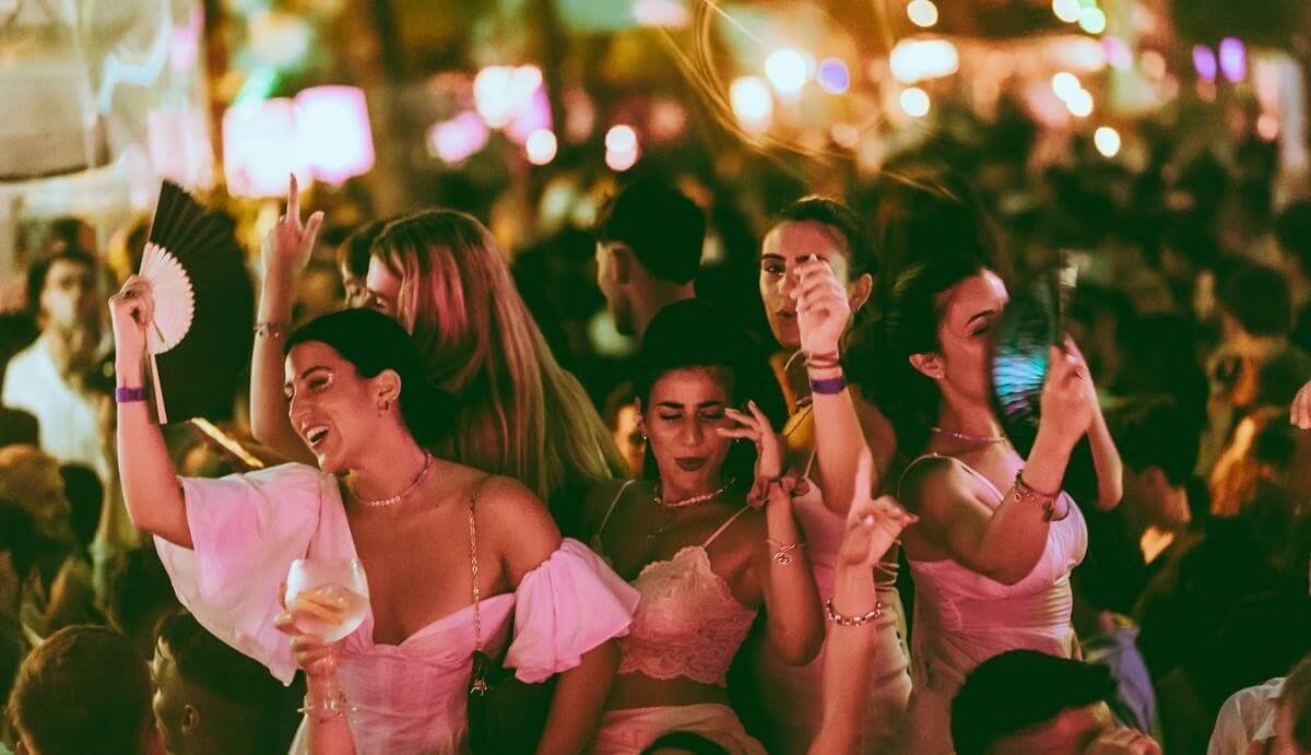 Crowd dancing and cheering during an open-air nightclub night in Valencia.