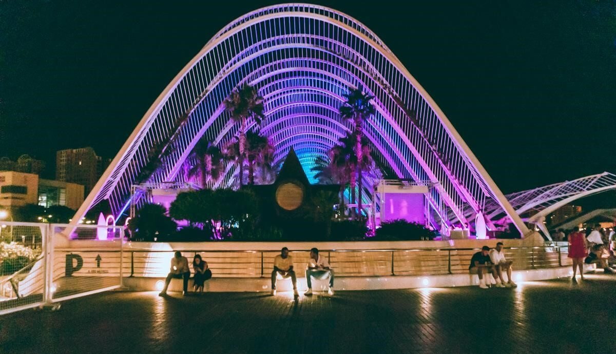 Illuminated arches at night with reflections in water near Valencia’s City of Arts and Sciences.