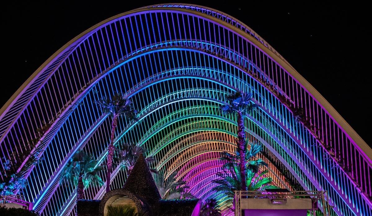 The iconic arched structure of L’Umbracle lit in purple and blue at night.