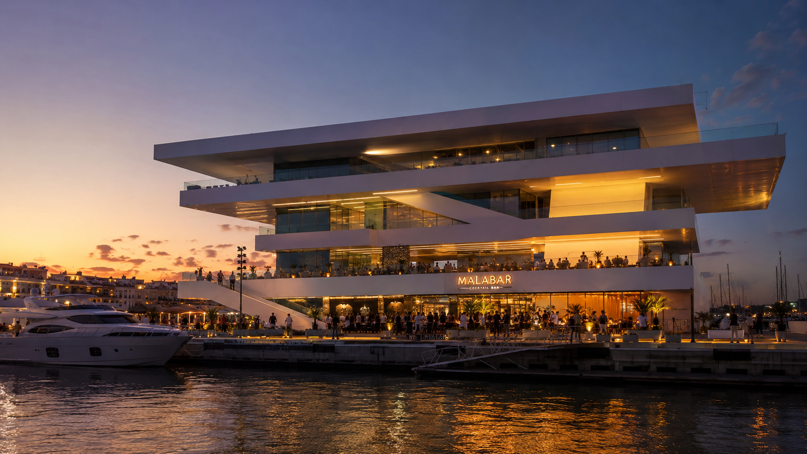 Malabar en el edificio Veles e Vents de Valencia al atardecer, con terraza iluminada, yates, ambiente elegante y vistas a la Marina de Valencia.